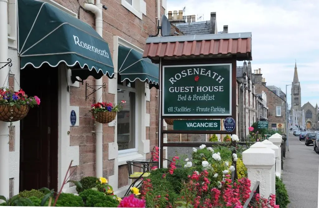 a sign for a guest house on a street at Roseneath Guest House in Inverness