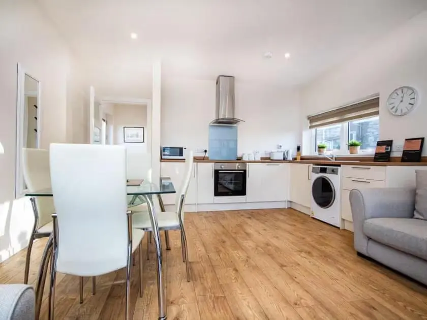 a kitchen and living room with a table and a couch at View Apartment in Inverness
