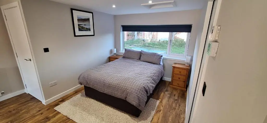 a small bedroom with a bed and a window at CeolMara in Ullapool