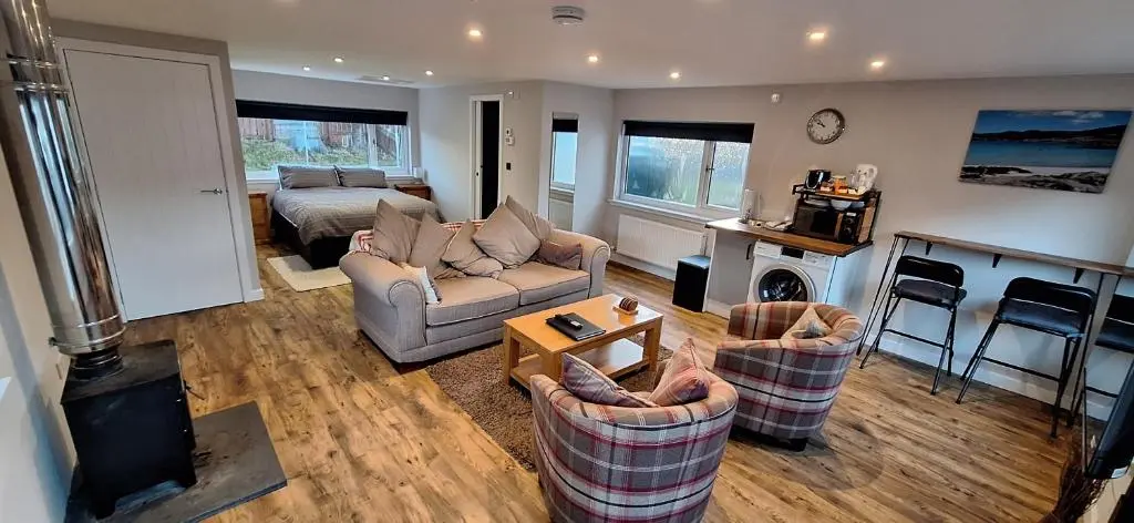 a living room with two couches and a bed at CeolMara in Ullapool