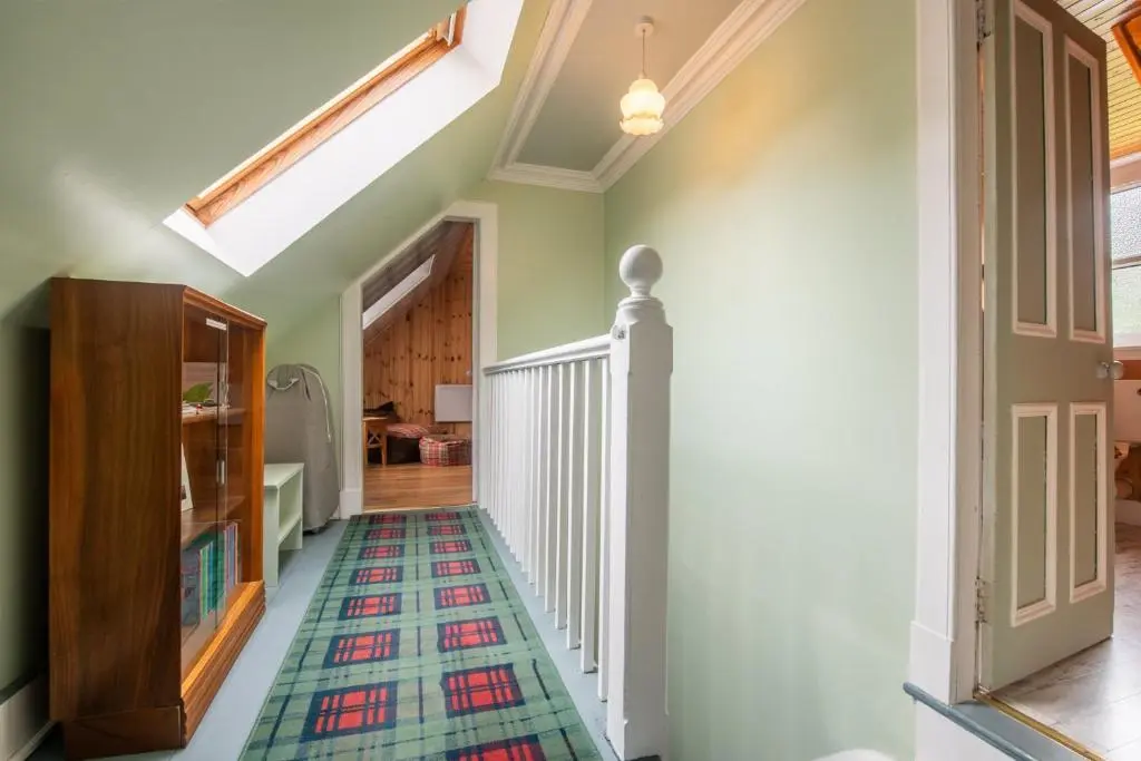 a hallway with a rug on the floor at Traditional Highland Cottage Near Loch Ness in Drumnadrochit