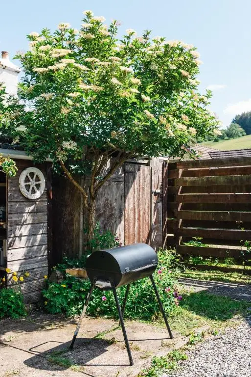 a black chair sitting in a yard next to a fence at Traditional Highland Cottage Near Loch Ness in Drumnadrochit