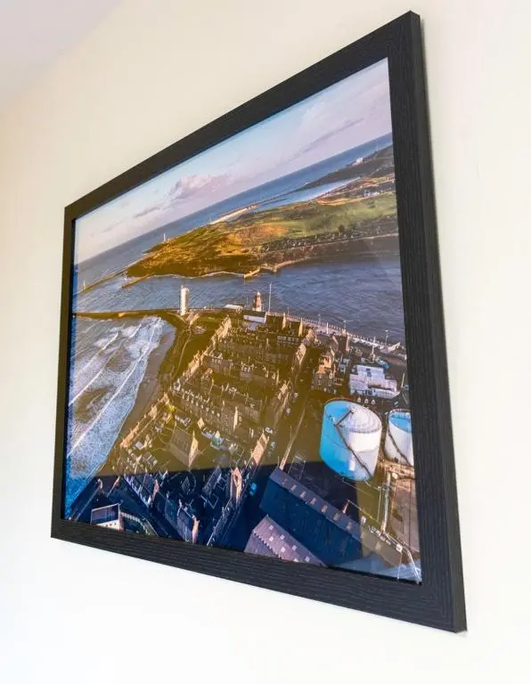 a framed picture of a city on a wall at Rosewood Cottage in Cornhill