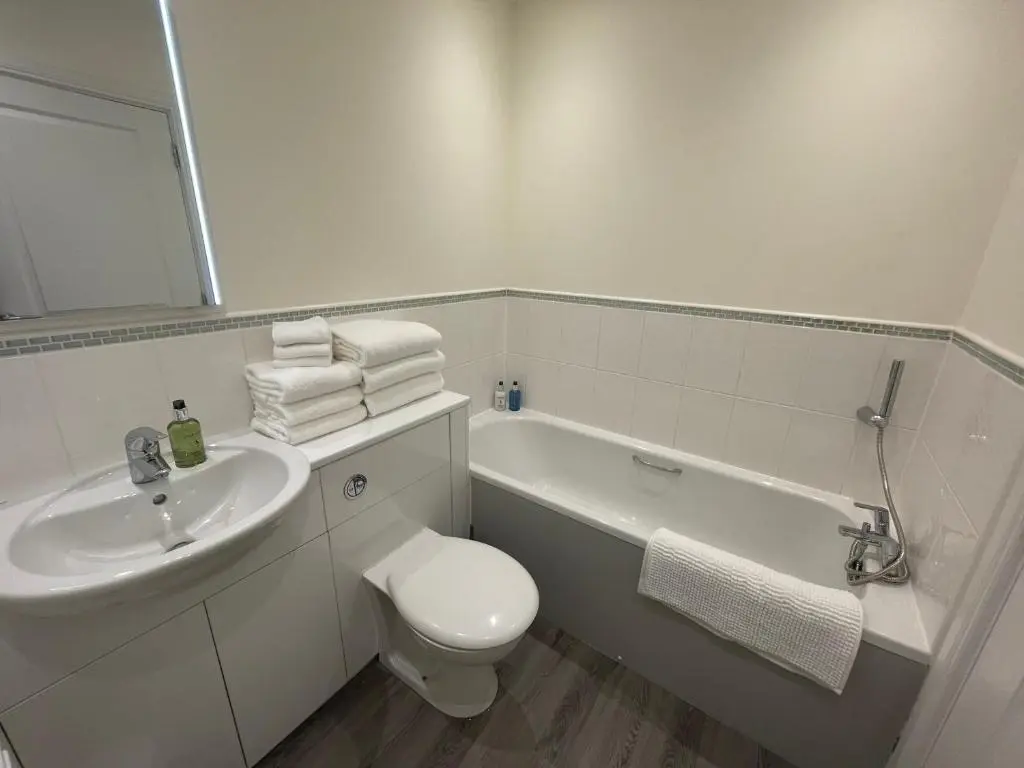 a white bathroom with a toilet and a sink at Inverness Retreat in Inverness