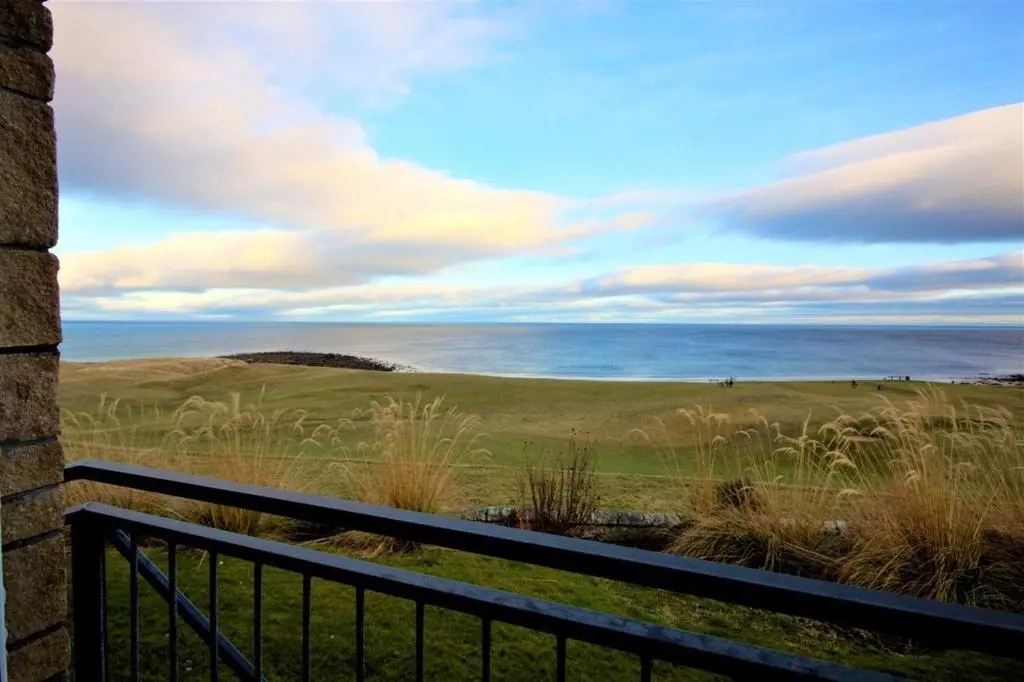 a view of the ocean from the balcony of a house at No10 The Links Apartment, Brora in Brora
