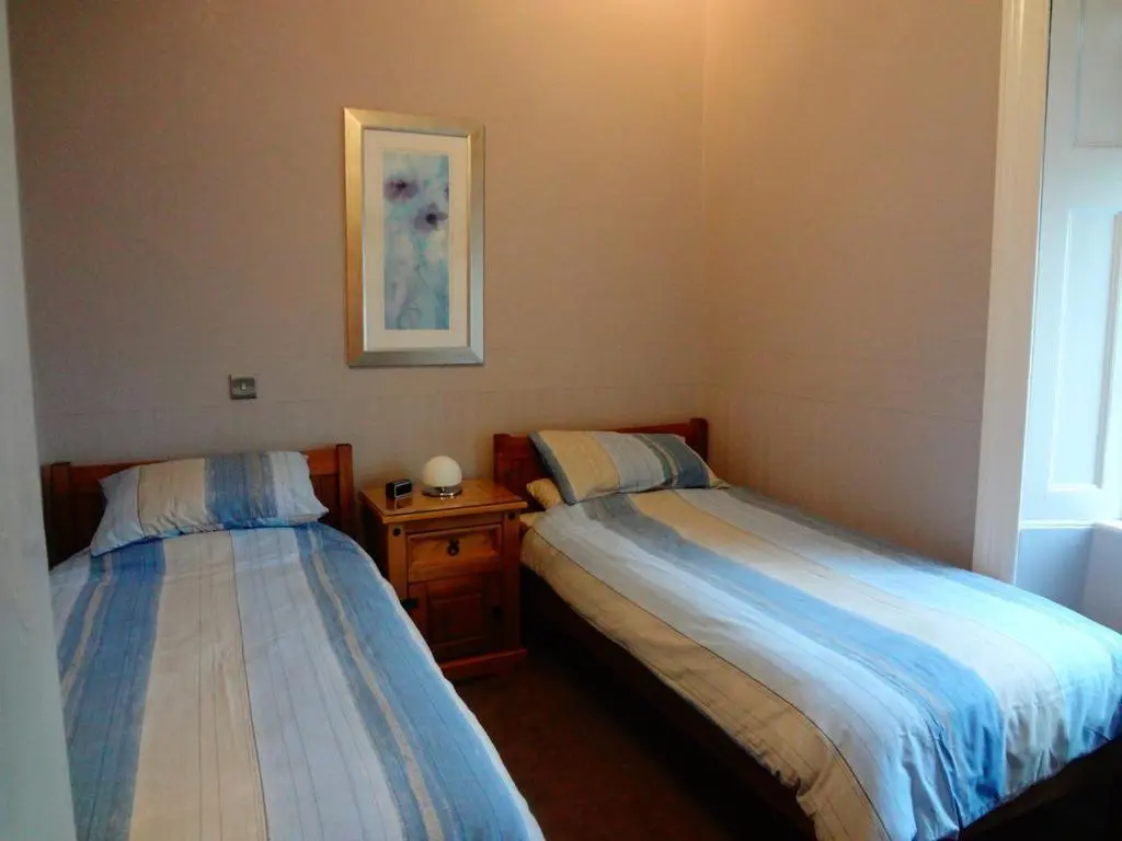 two beds in a small room withermottermottermottermott at Macbeth Arms in Lumphanan