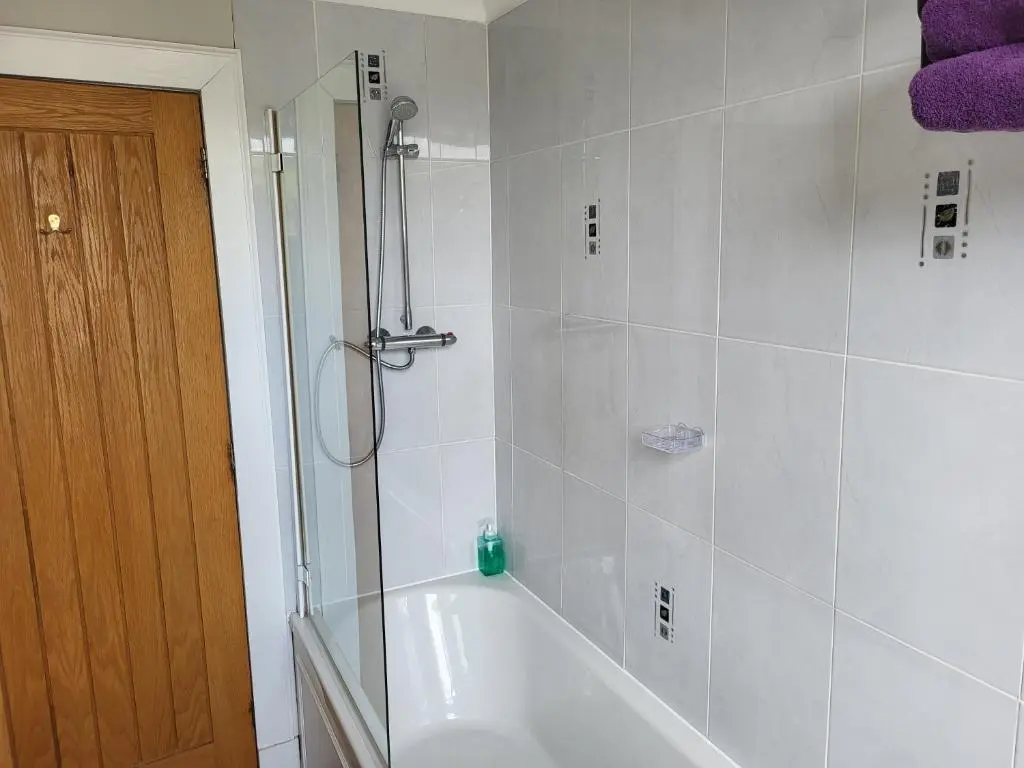a bathroom with a shower and a bath tub at Macbeth Arms in Lumphanan