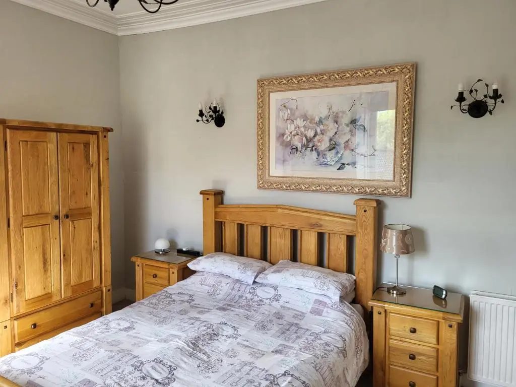 a bedroom with a bed and a picture on the wall at Macbeth Arms in Lumphanan