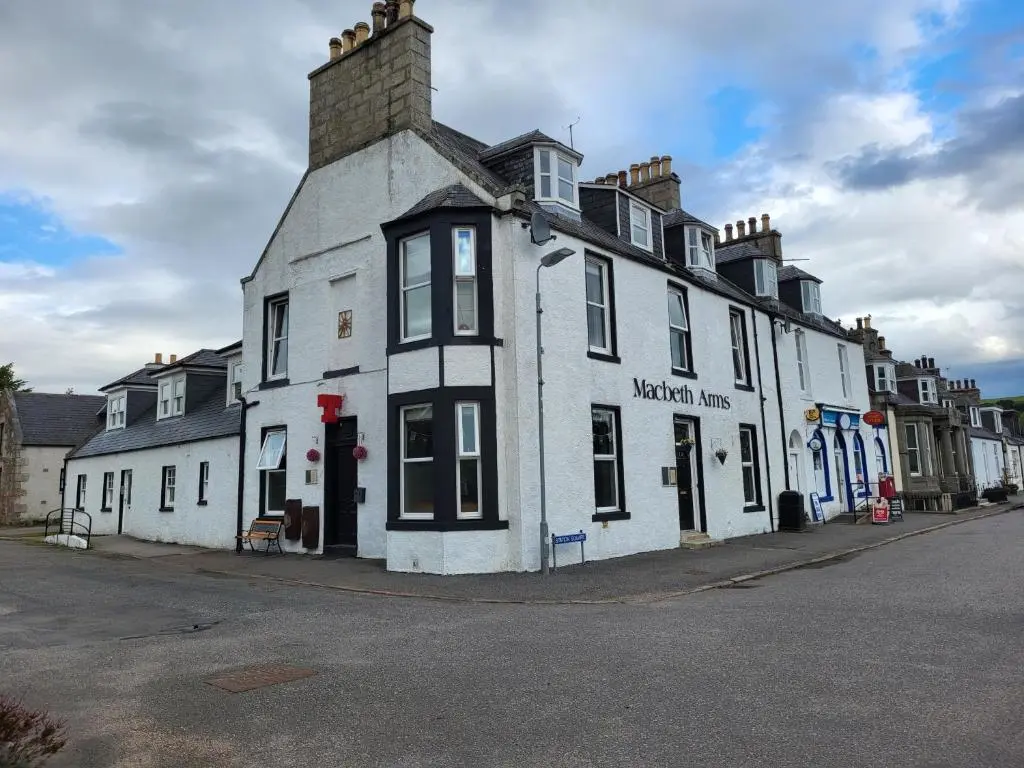 a white building on the side of a street at Macbeth Arms in Lumphanan