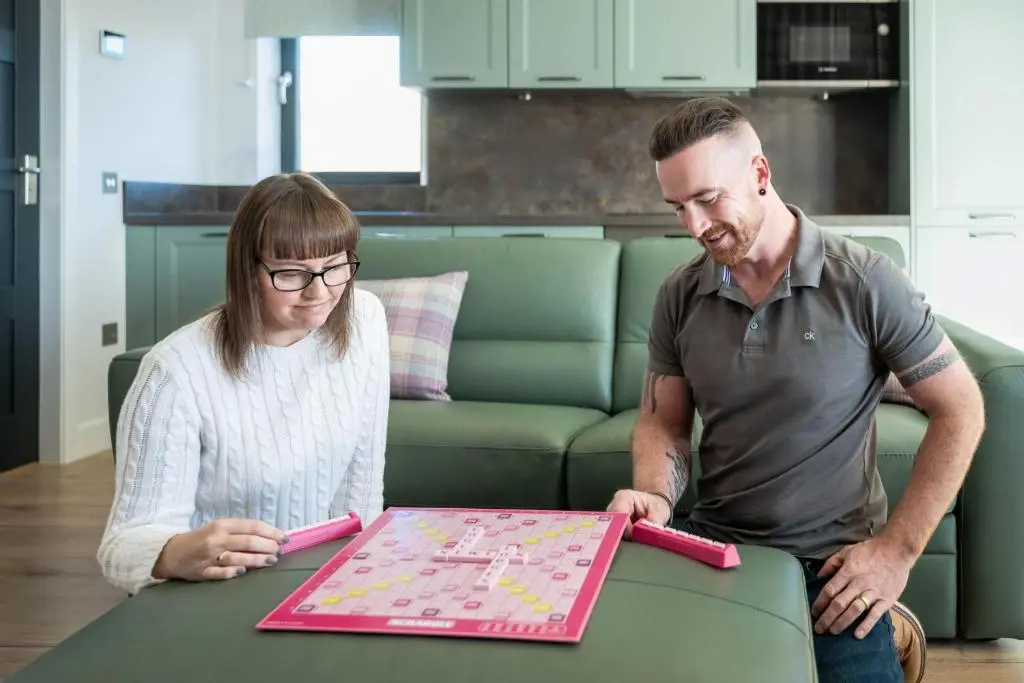 a man and a woman looking at a game on a table at Bennachie Lodge in Huntly