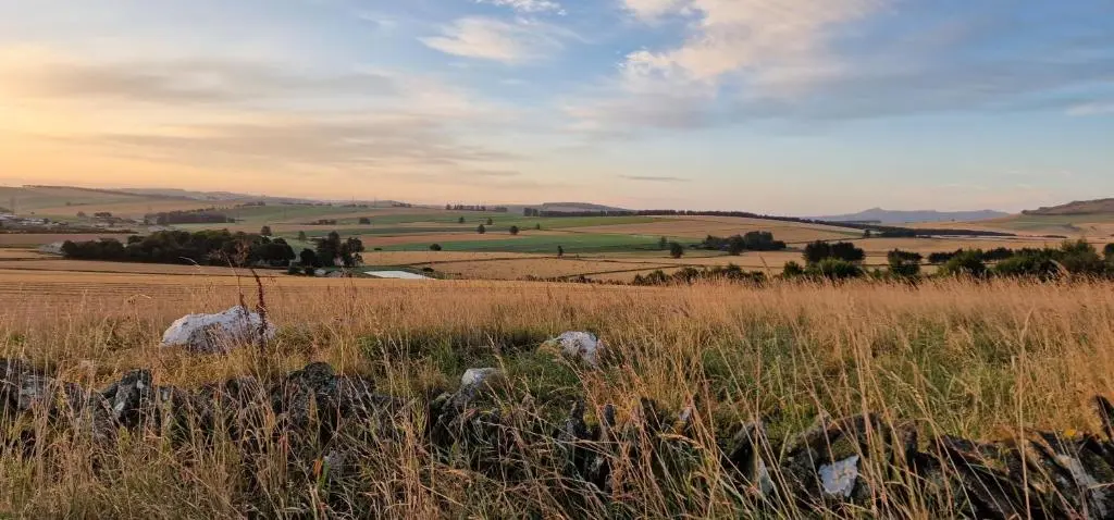 a field of grass with the sky in the background at Woodland Lodge in Huntly