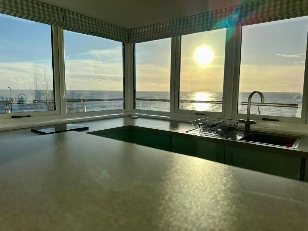a kitchen with a sink and a view of the ocean at The Old Coastguard Station in Helmsdale