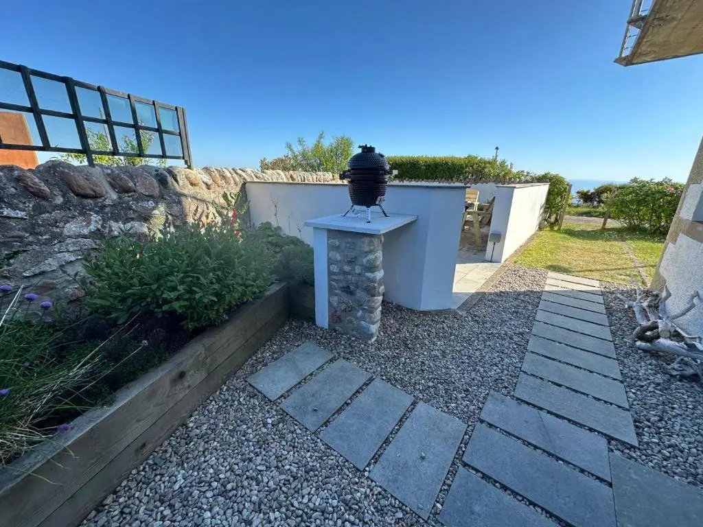 a garden with a light on a table next to a wall at The Old Coastguard Station in Helmsdale