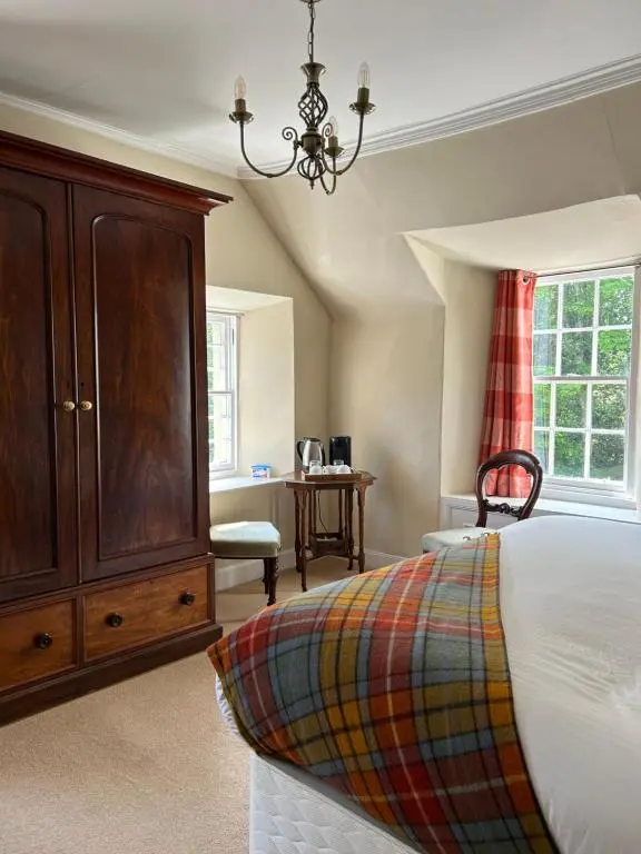 a bedroom with a large bed and a dresser at Estate Of Ord in Muir of Ord