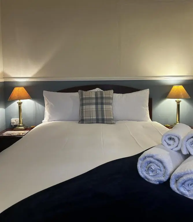a bedroom with a large bed with towels on it at Estate Of Ord in Muir of Ord