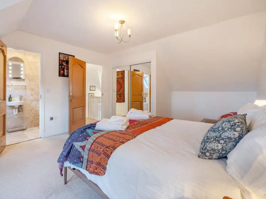 a bedroom with a large white bed and a bathroom at Stunning 4 bed rural retreat in Aberlour in Aberlour
