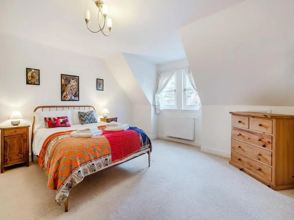 a bedroom with a bed and a dresser and a window at Stunning 4 bed rural retreat in Aberlour in Aberlour