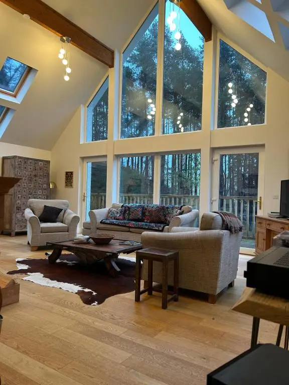 a large living room with large windows and couches at Stunning 4 bed rural retreat in Aberlour in Aberlour