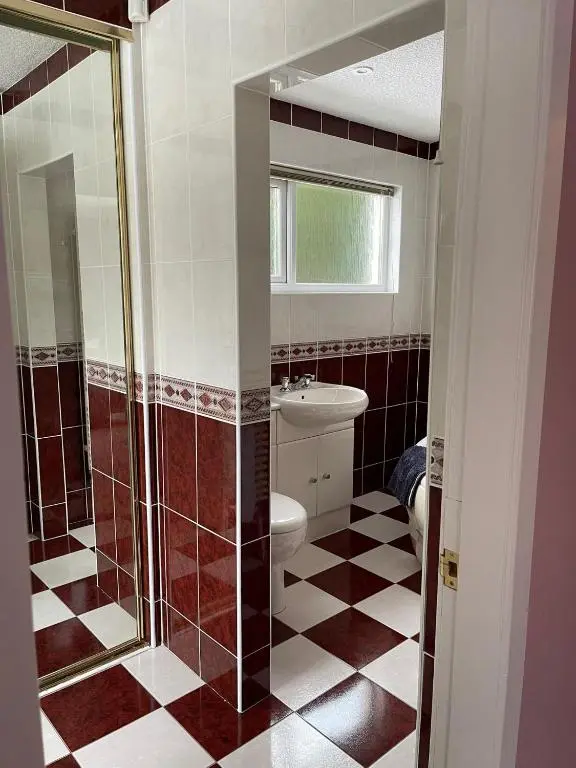 a bathroom with a toilet and a glass shower at Runnymede House in Inverness