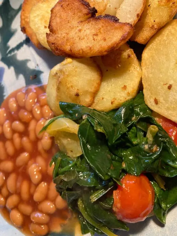 a plate of food with beans and greens at Runnymede House in Inverness
