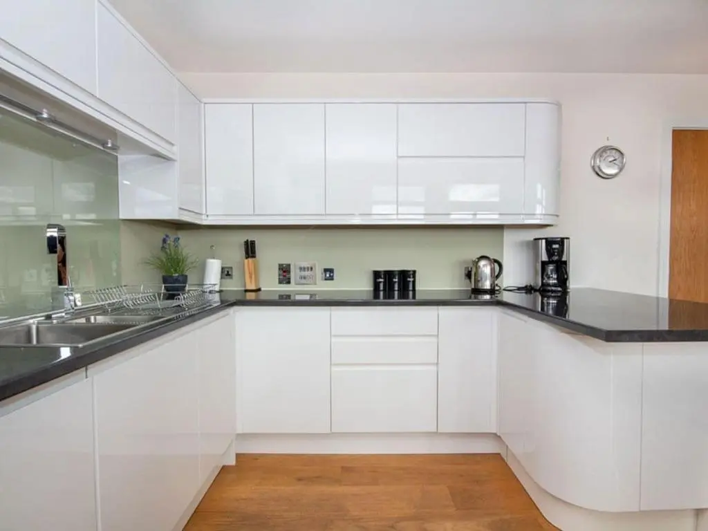 a white kitchen with white cabinets and a sink at 2 Bedroom Riverside Apartment 301-Free Parking in Inverness