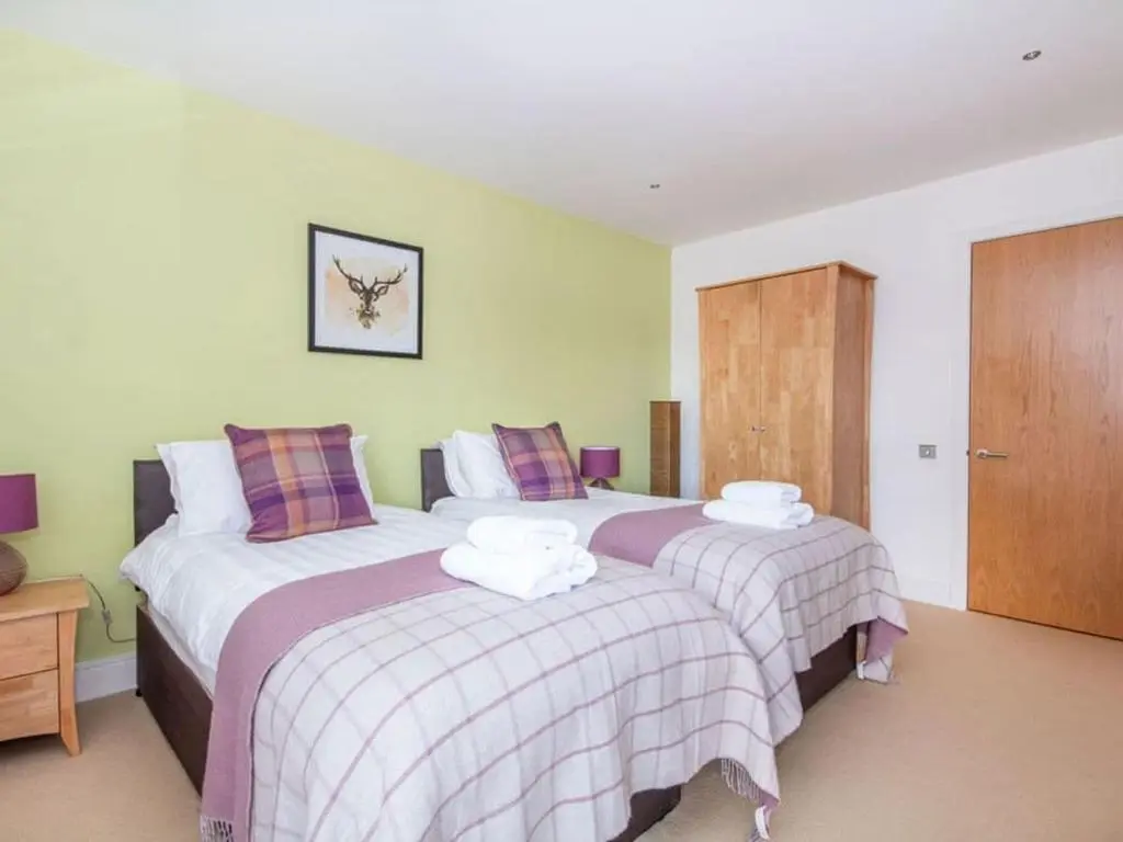 two beds in a hotel room with two bedsvisor at 2 Bedroom Riverside Apartment 301-Free Parking in Inverness