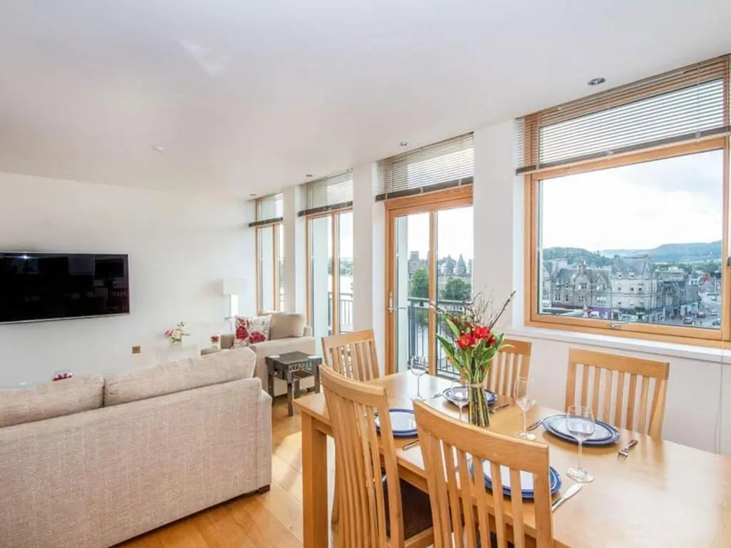 a living room with a couch and a table at 2 Bedroom Riverside Apartment 301-Free Parking in Inverness
