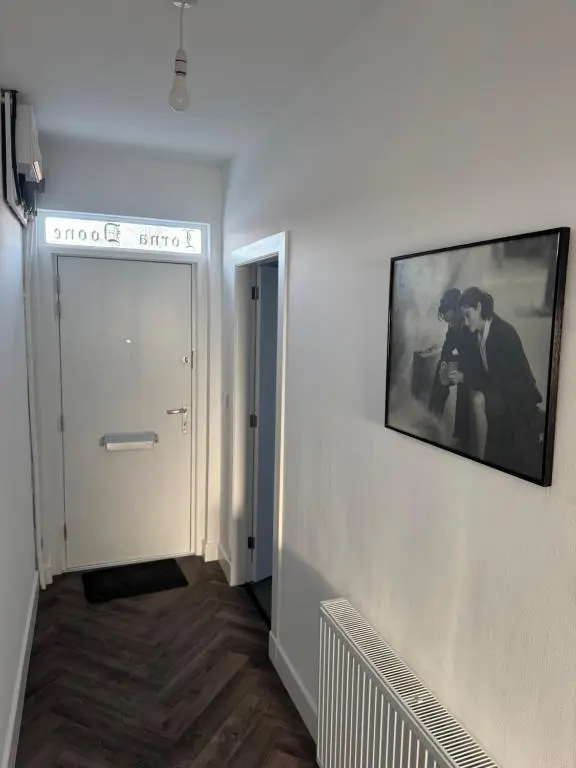 a hallway with a picture of two men on a wall at Lorna Doune in Port Elphinstone