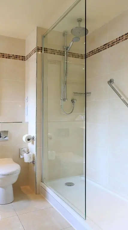 a bathroom with a shower with a glass door at Macdonald Morlich Hotel at Macdonald Aviemore Resort in Aviemore