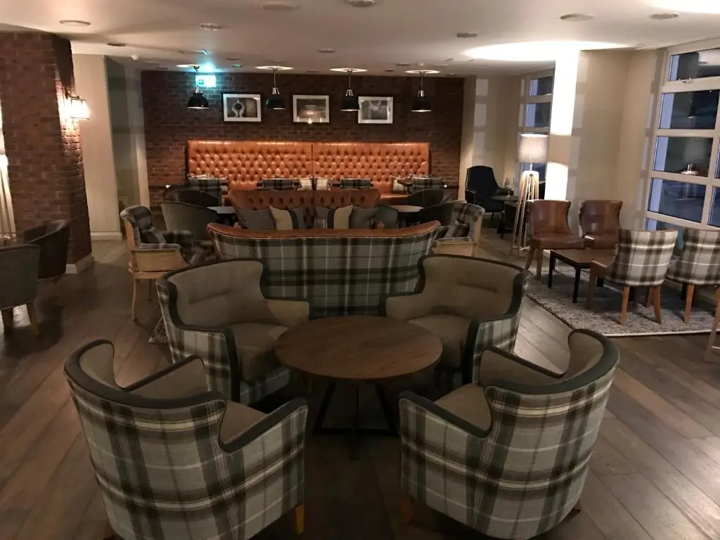 a restaurant with chairs and tables and a bar at Macdonald Morlich Hotel at Macdonald Aviemore Resort in Aviemore