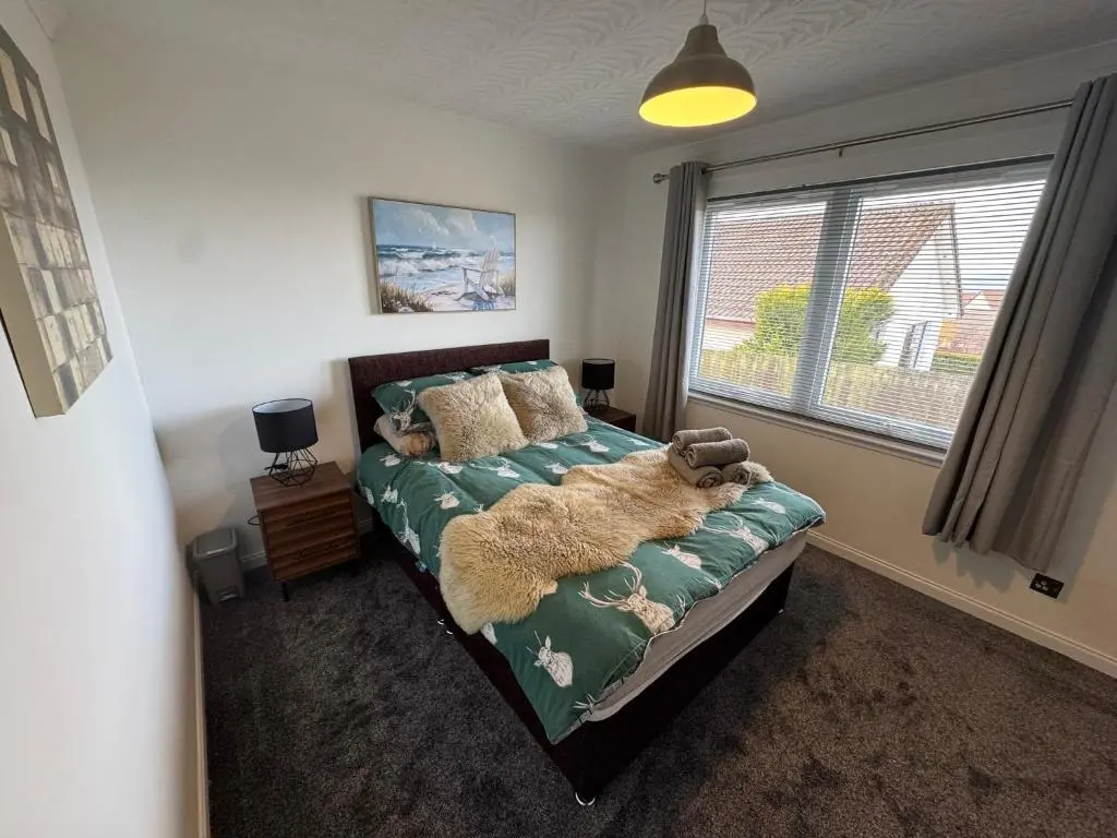 a bedroom with a bed with a teddy bear on it at Firth View Heights in Inverness