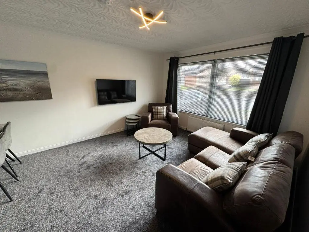 a living room with a couch and a tv at Firth View Heights in Inverness