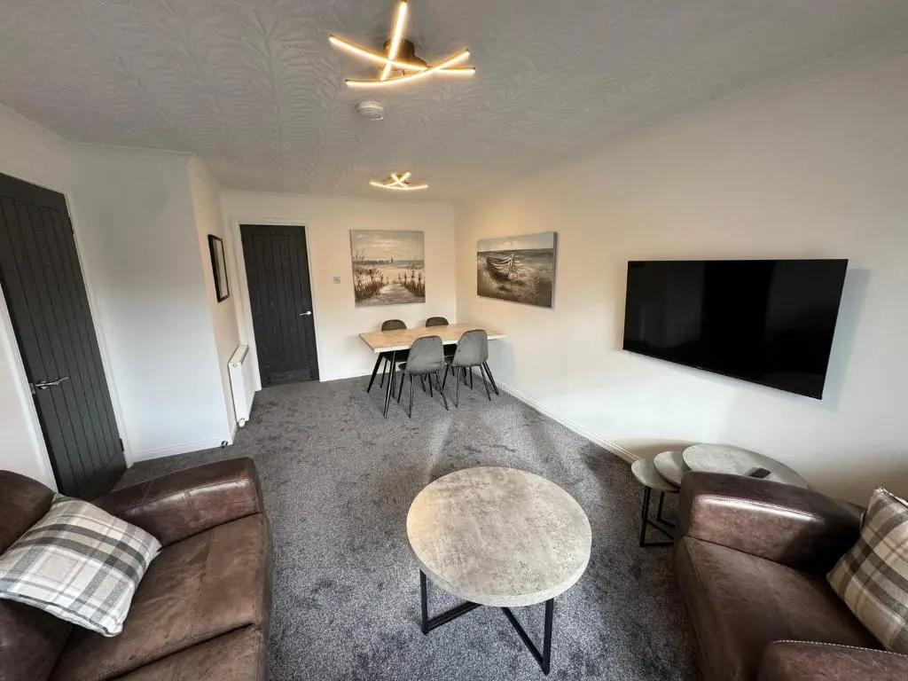 a living room with a couch and a table at Firth View Heights in Inverness
