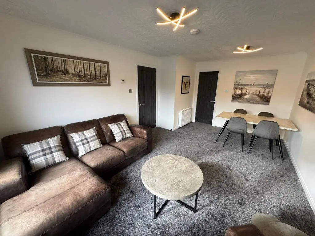 a living room with a couch and a table at Firth View Heights in Inverness
