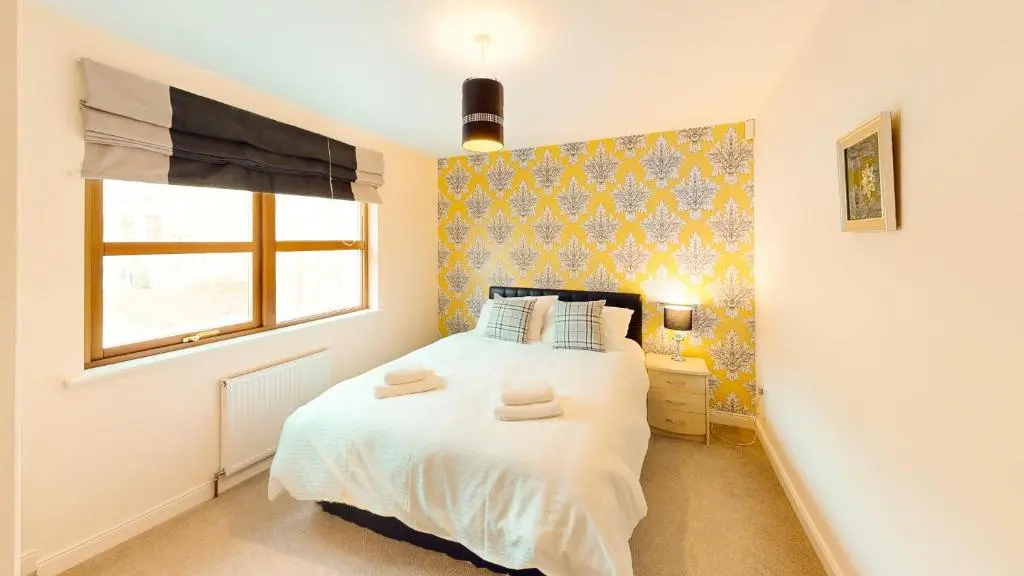a bedroom with a bed with two towels on it at Lairig Ghru Lodge in Aviemore
