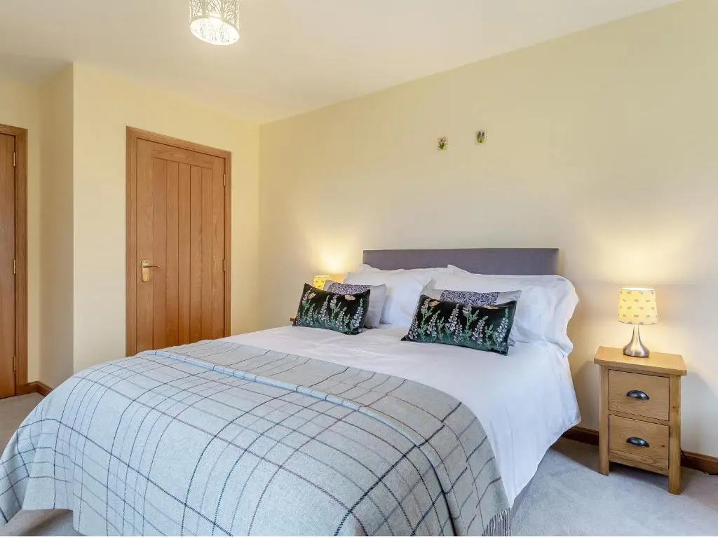a bedroom with a bed with two pillows on it at Bunchrew Farm Cottage in Inverness