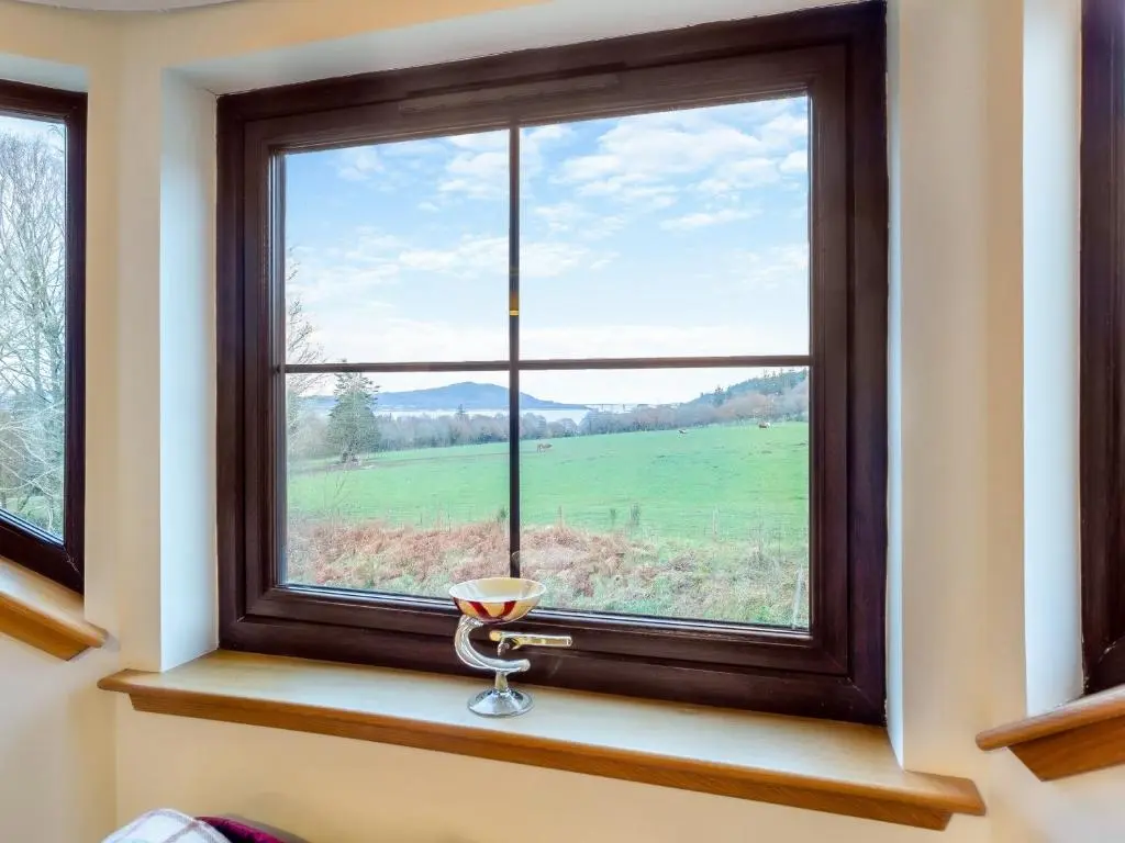 a window with a view of a green field at Bunchrew Farm Cottage in Inverness