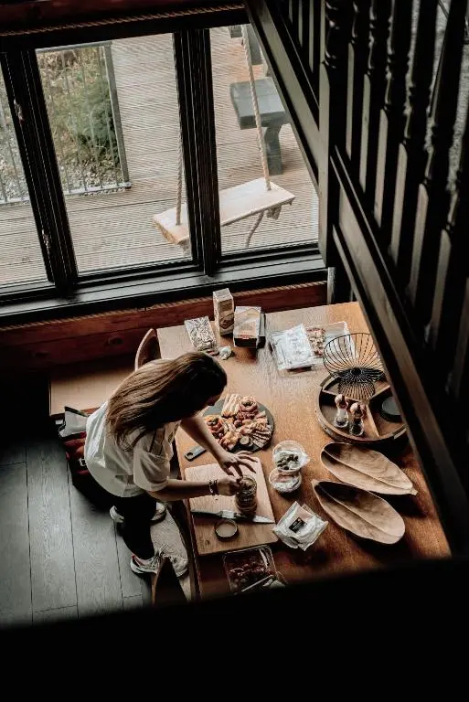a woman sitting at a table with food on it at Lodges On Loch Ness in Inverness