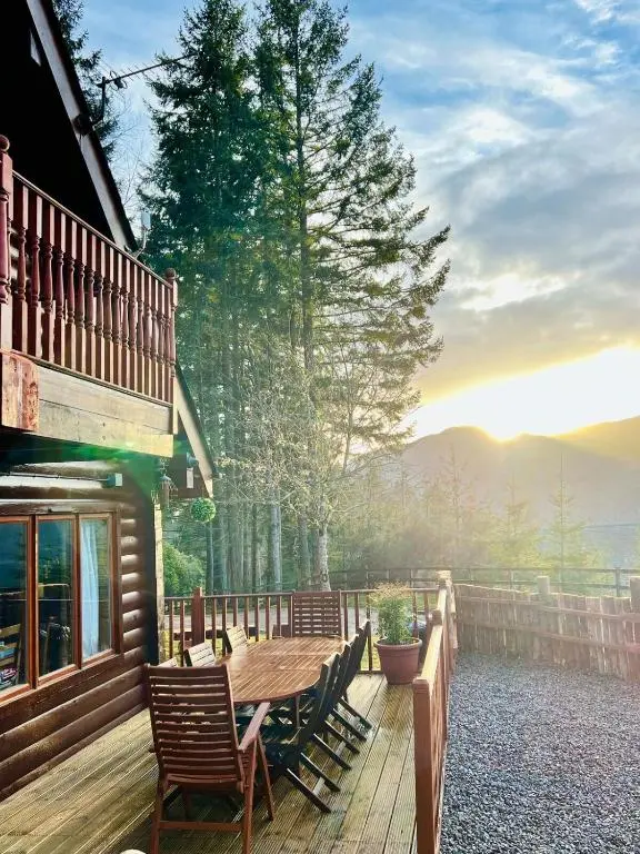a wooden deck with a wooden table and chairs at Lodges On Loch Ness in Inverness