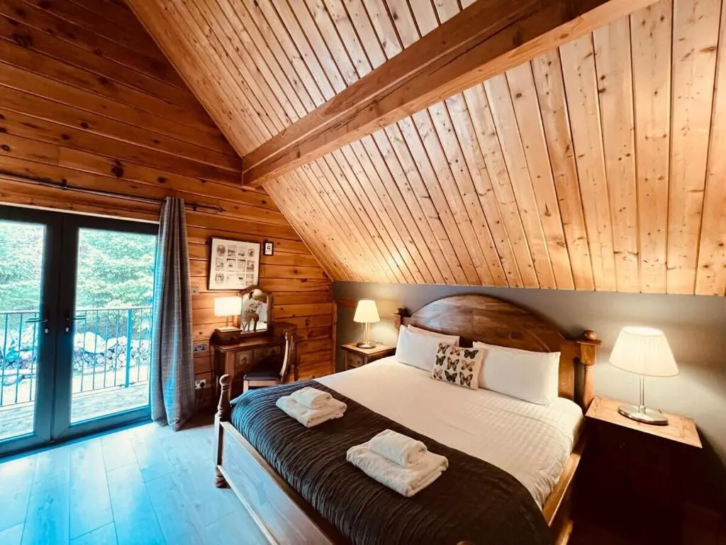 a bedroom with a large bed with a wooden ceiling at Lodges On Loch Ness in Inverness