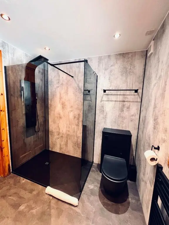 a bathroom with a glass shower and a toilet at Lodges On Loch Ness in Inverness