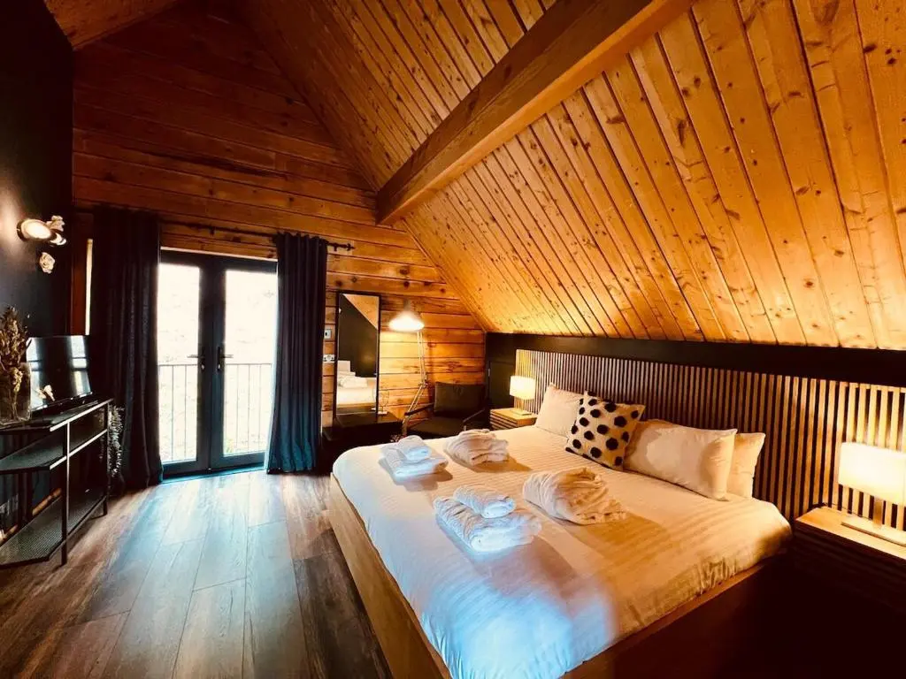 a bedroom with a large bed with a wooden ceiling at Lodges On Loch Ness in Inverness