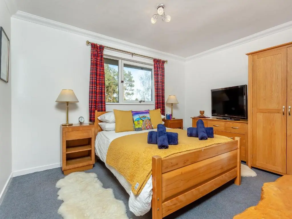 a bedroom with a large bed and a tv at Rock Folly in Inverness