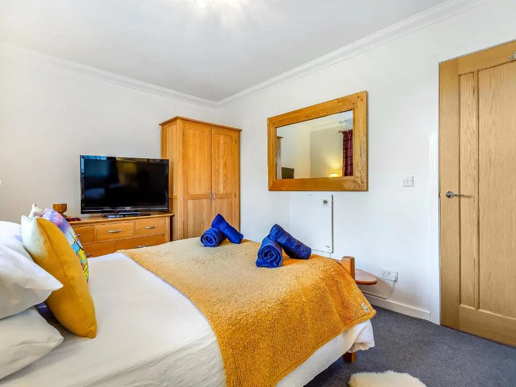 a bedroom with a bed with blue towels on it at Rock Folly in Inverness