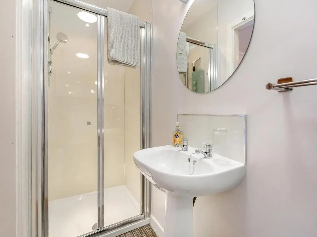 a white bathroom with a sink and a shower at Rock Folly in Inverness