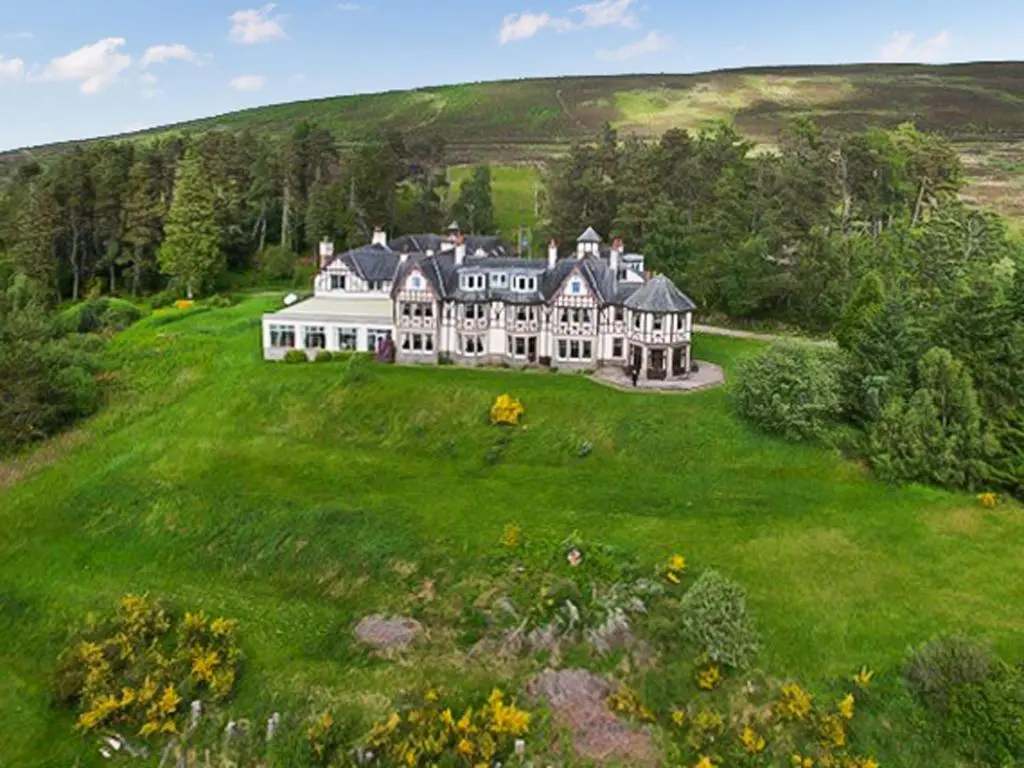 a large white house on a green field at The Carnegie Rooms At Aultnagar Lodge - Uk48666 in Lairg