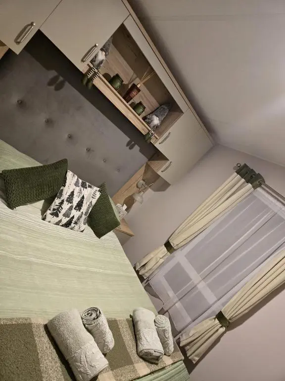 a bedroom with a bed with towels on it at Lynmar retreat No 35 in Dornoch