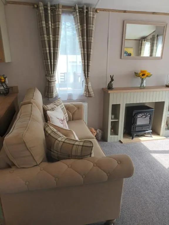 a living room with a couch and a fireplace at Lynmar retreat No 35 in Dornoch