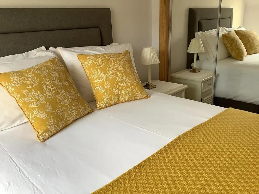 a large white bed with yellow pillows in a bedroom at 244 Seatown Cullen Moray Scotland in Cullen