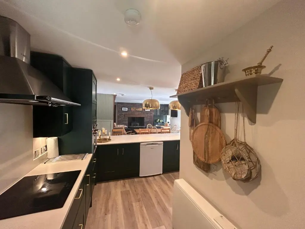 a kitchen with black and white cabinets and a counter at Aldernaig Mill in Invergarry
